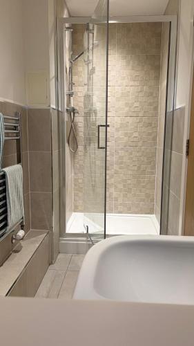 a bathroom with a shower and a bath tub at Quayside Waters in Dundee