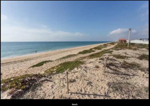 an empty beach with the ocean in the background at Blife Mariangya private rooms at Faro beach in Faro