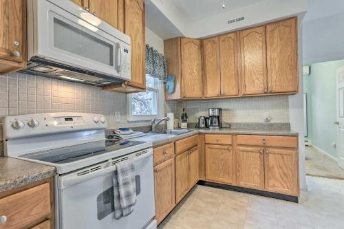 een keuken met witte apparaten en houten kasten bij Spacious Lakefront House With a Private Dock in Hopatcong