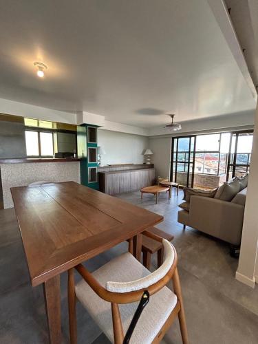 a living room with a wooden table and a couch at Apartamento Outeiro in Ilhéus