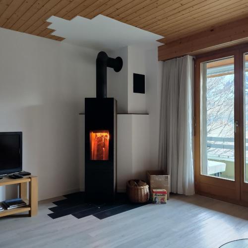 a living room with a wood stove in the wall at Ferienwohnung Halden in Unterwasser
