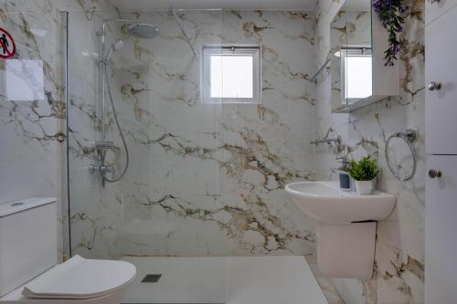 a bathroom with a toilet sink and a shower at Makenzy Sandy Beachfront Paradise in Larnaca