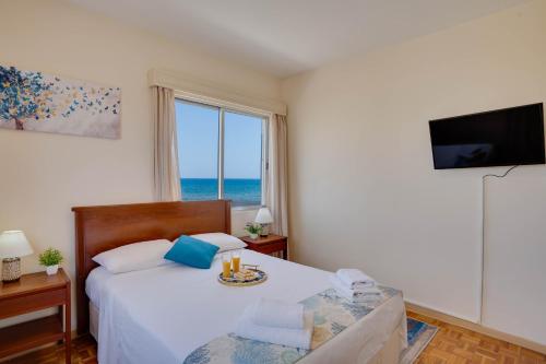 En eller flere senge i et værelse på Makenzy Sandy Beachfront Paradise