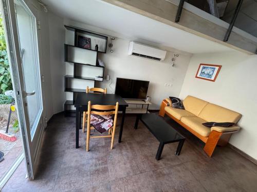 een kamer met een bureau, een bank en een tafel bij Loft Appartement Les Angles 30133 Possibilité jacuzzi in Les Angles Gard