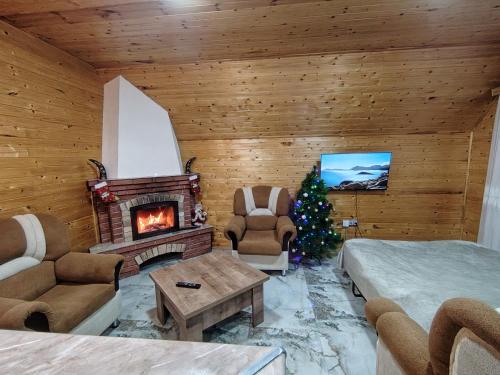 un salon avec un arbre de Noël et une cheminée dans l'établissement Qusar A-Frame, à Qusar