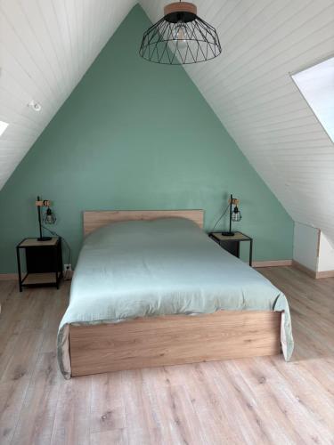 ein Schlafzimmer mit einem Bett auf einem Dachboden in der Unterkunft Gîtes du phénix in Pont-Aven