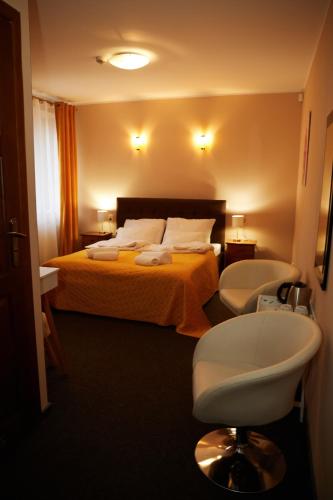 a hotel room with a bed and a chair at PLATINIUM House ex Royal House in Białogard
