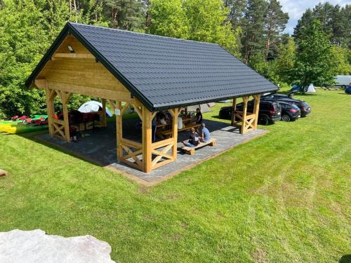 Eine Gruppe von Menschen sitzt in einem Pavillon in einem Park. in der Unterkunft Kajakiem z Marzysza in Marzysz
