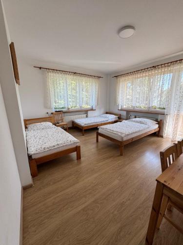 a room with three beds in it with windows at Kajakiem z Marzysza in Marzysz