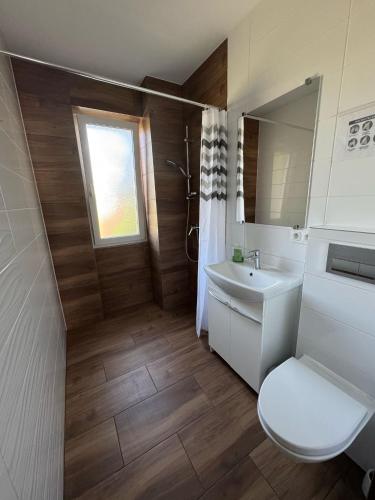 a bathroom with a white toilet and a sink at Kajakiem z Marzysza in Marzysz