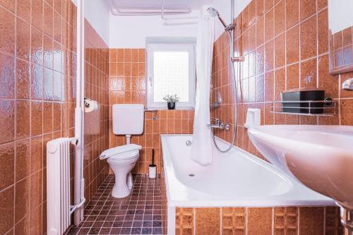 een badkamer met een wastafel, een toilet en een bad bij Ferienhaus Lotta in Umhausen