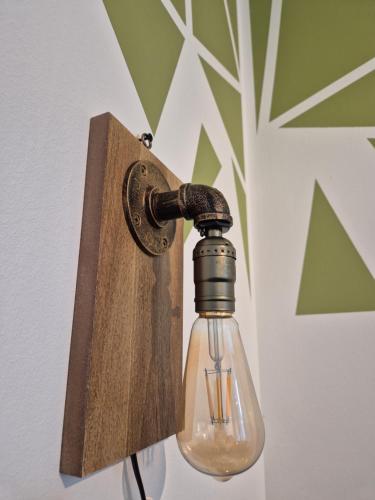 una luce con una bottiglia di vetro attaccata a una parete di Ferienwohnung - ZeitRaum a Gemünden