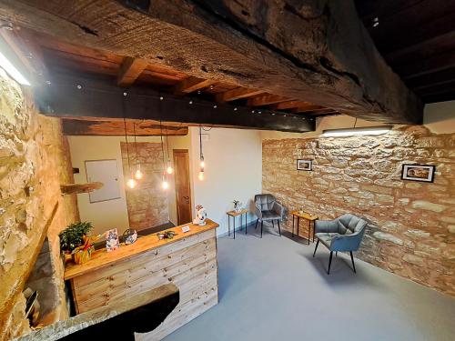 een woonkamer met een stenen muur en 2 stoelen bij IL MOLINO del SIGNORE in Pergola