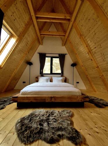 een slaapkamer met een groot bed op zolder bij Amurg in Lupeni