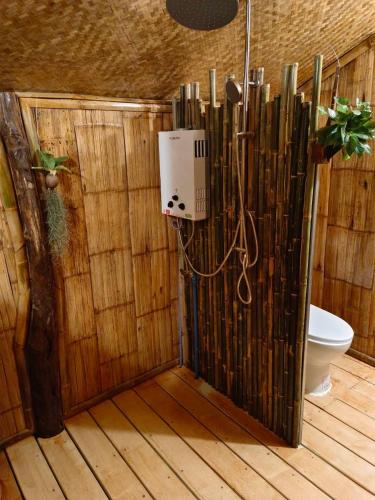 a bathroom with a toilet and a wooden wall at Lazy mango homestay in Ban Mae Sapok Nua