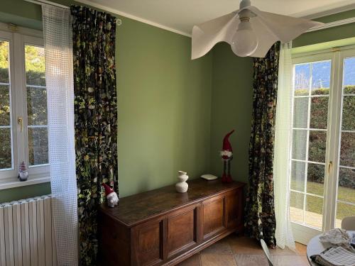 una stanza con pareti verdi e finestre con tende di Dimora degli Gnomi a Tirano