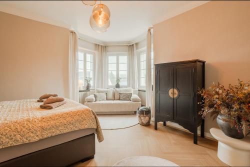 ein Schlafzimmer mit einem Bett und einer Couch in der Unterkunft Villa Vulkaneifel in Kelberg