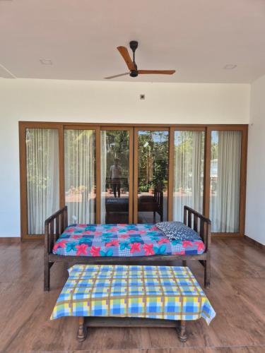 two beds in a room with sliding glass doors at Prabhu Villla Upper Deck in Perumpāvūr