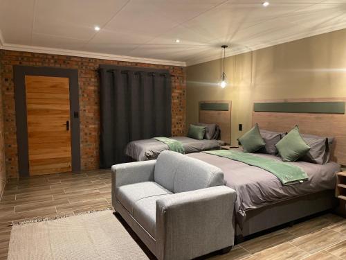 a bedroom with two beds and a couch in it at Lemon Tree Guest House in Aliwal North