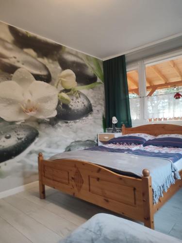a bedroom with two beds and a wall with flowers at Willa Izerka BALIA JACUZZI SAUNA BILLARD in Świeradów-Zdrój
