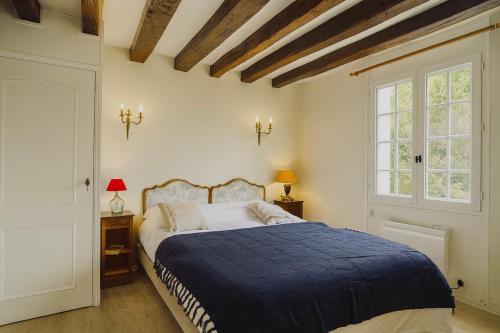 a bedroom with a large bed with a blue blanket at Domaine Les Pigées in Saint-Privé