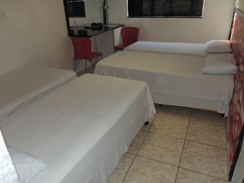 En eller flere senge i et værelse på Ouro Hotel