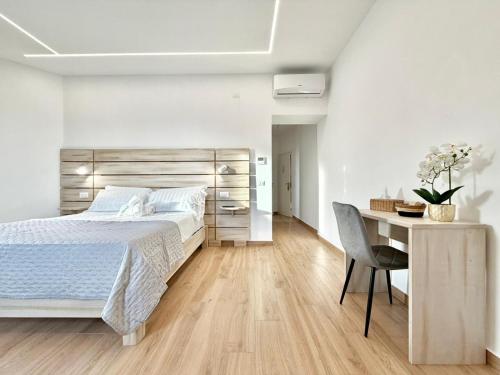 a white bedroom with a bed and a desk at Maison Plancina in Rome