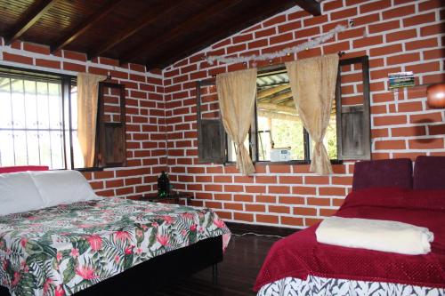 a bedroom with a brick wall and a bed and windows at Serene Soul Arroyave in Medellín