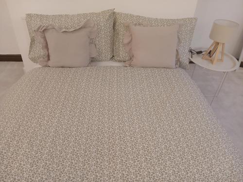 een bed met vier kussens en een tafel met een lamp bij Central Bewdley - Load Street Retreat in Bewdley