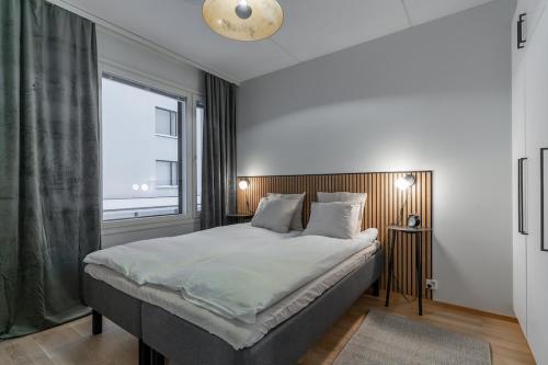 a bedroom with a large bed and a window at Scandi Forest Flat Across from the Train Station in Rovaniemi
