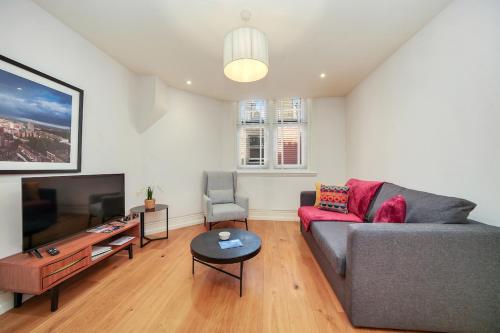 a living room with a couch and a tv at Central London Stylish Living -1BR Apt in WC2 in London