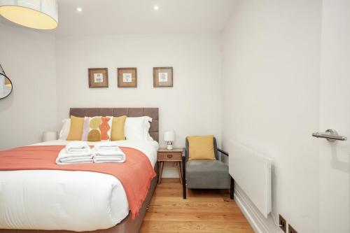 a bedroom with a bed and a chair at Central London Stylish Living -1BR Apt in WC2 in London