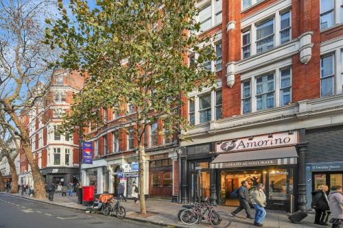 a group of people walking down a city street at Central London Stylish Living -1BR Apt in WC2 in London