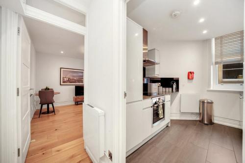 a hallway with white walls and wooden floors at Central London Stylish Living -1BR Apt in WC2 in London