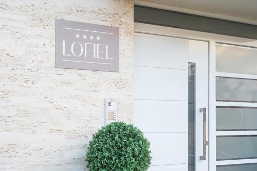 a sign on the side of a building with a door at Apartments Lofiel in Novalja