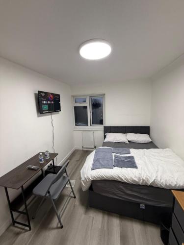 a bedroom with a bed and a table and a desk at Modern Rooms in North London in Edmonton