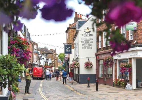 a city street with people walking down the street at Stylish Mews House, Private Garden, Sleeps 4, Central Location in Twickenham