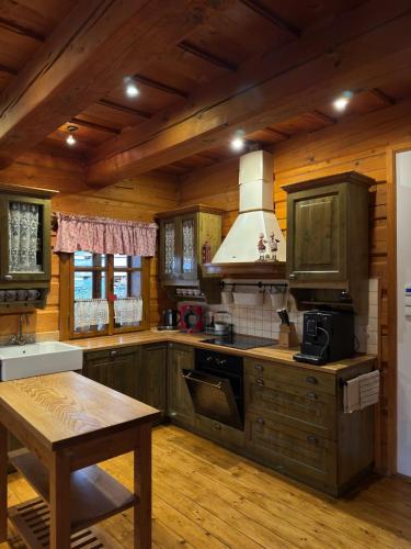 a kitchen with wooden cabinets and a table in a cabin at Roubená chalupa Lysečinky A in Trutnov