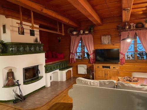 a living room with a couch and a tv at Roubená chalupa Lysečinky A in Trutnov