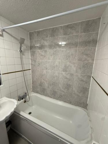 ein Badezimmer mit einer weißen Badewanne und einem Waschbecken in der Unterkunft Modern Rooms in North London in Edmonton