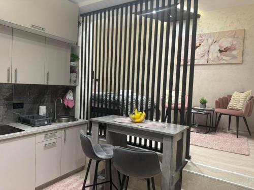 a kitchen with a table and chairs in a room at ELLA LUX APARTMAN Čačak in Čačak