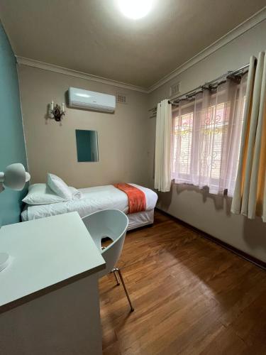 una piccola stanza con due letti e una finestra di Crème de la crème a Durban