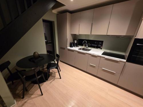 een keuken met een zwarte tafel en een tafel en stoelen bij House with great location in Trysil