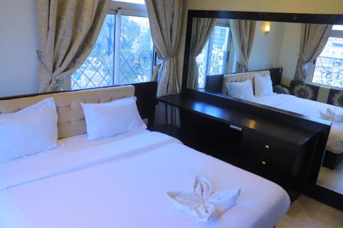 Al Jardāʼفندق غلاديلاس的有两张床和一面镜子的卧室