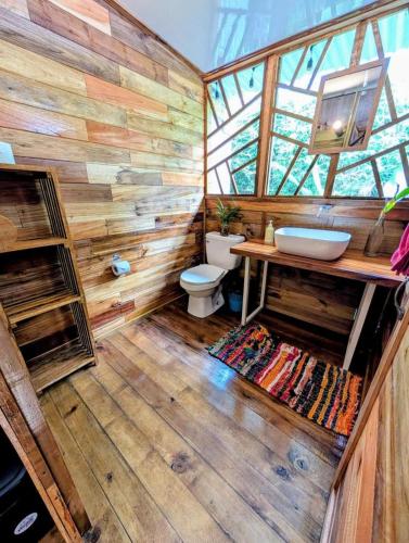 a wooden bathroom with a toilet and a sink at Arbura in Uvita
