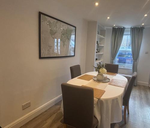 a dining room with a table and chairs at Adrian Cottage in Abbots Langley
