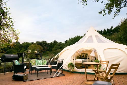 ein großes weißes Zelt mit Stühlen und einem Tisch in der Unterkunft Victoria Plum in Cropthorne
