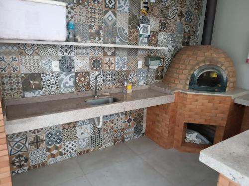 eine Küche mit Spüle und Steinofen in der Unterkunft Barra prime 1539 in Barra dos Coqueiros