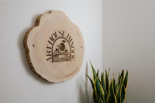 a wooden sign hanging on a wall next to a plant at Art House HINODE 10 people 3 minutes from the station Art and Tokyo Bay spectacular ocean view in Tokyo