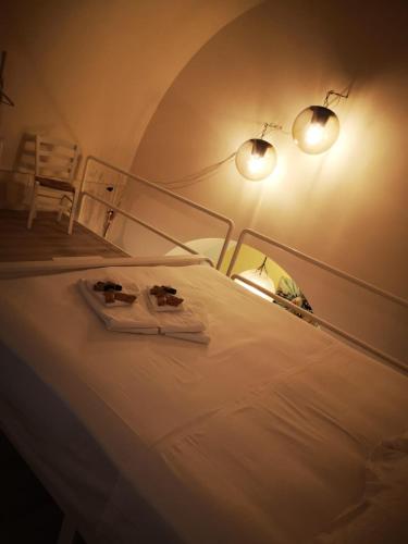 een slaapkamer met een bed met 2 handdoeken en 2 verlichting bij Dimora Daliah&Oana in Matera